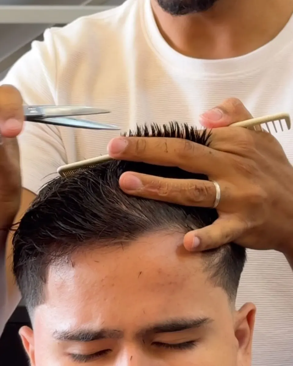 Ryan Gomes acertando a textura do cabelo com tesoura e pente